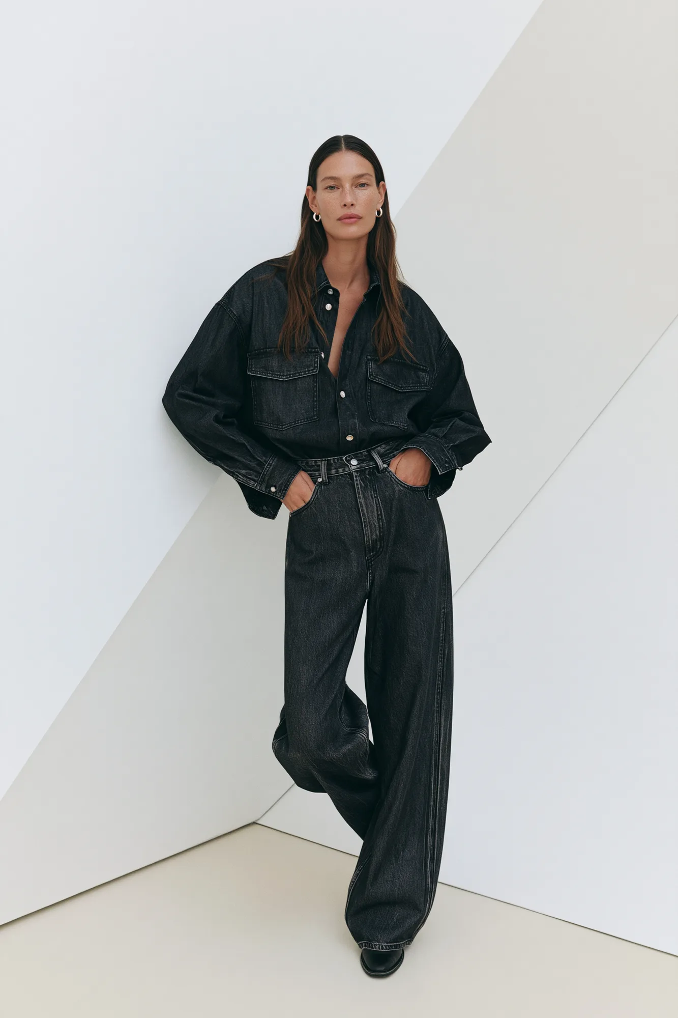Model in a black denim set on a white geometric set