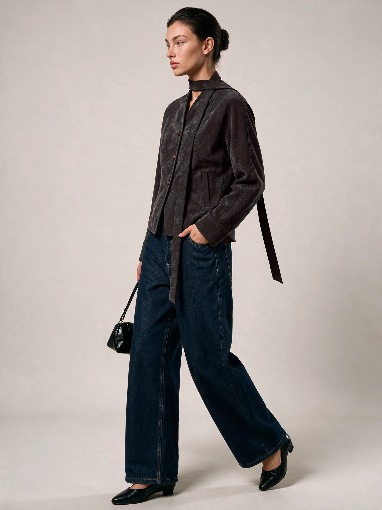 Model wearing a dark cropped jacket with wide denim
