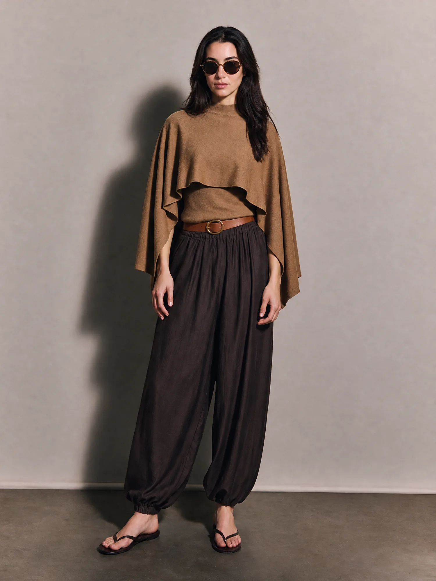 Model wearing a brown cape knit with relaxed trousers