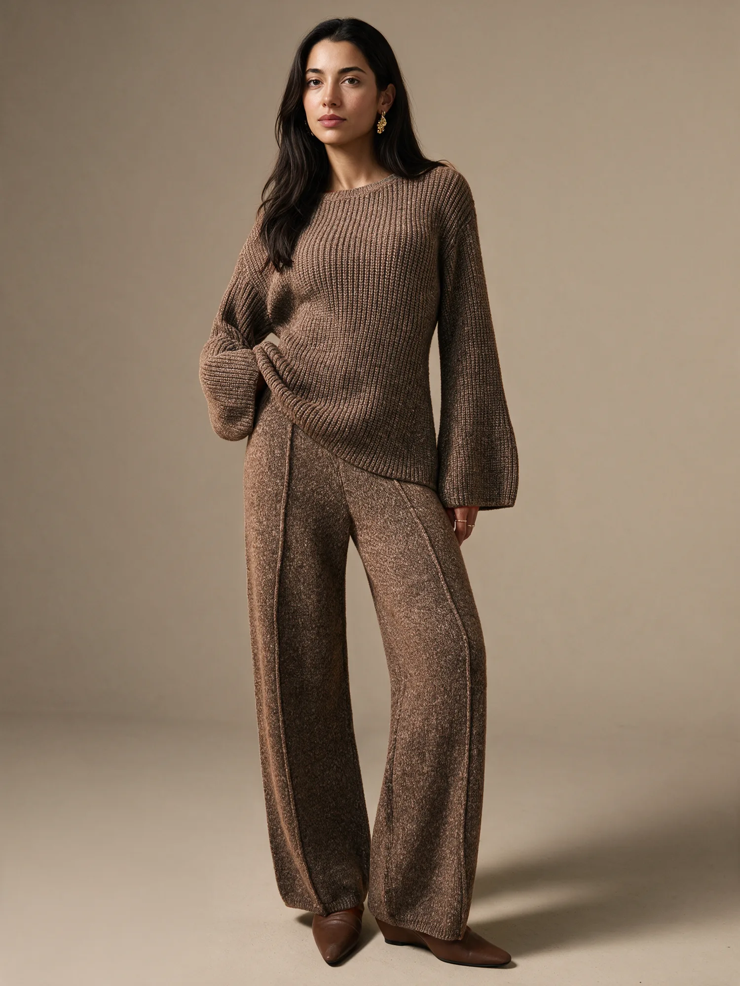 Model wearing a brown knit set on a warm neutral studio background