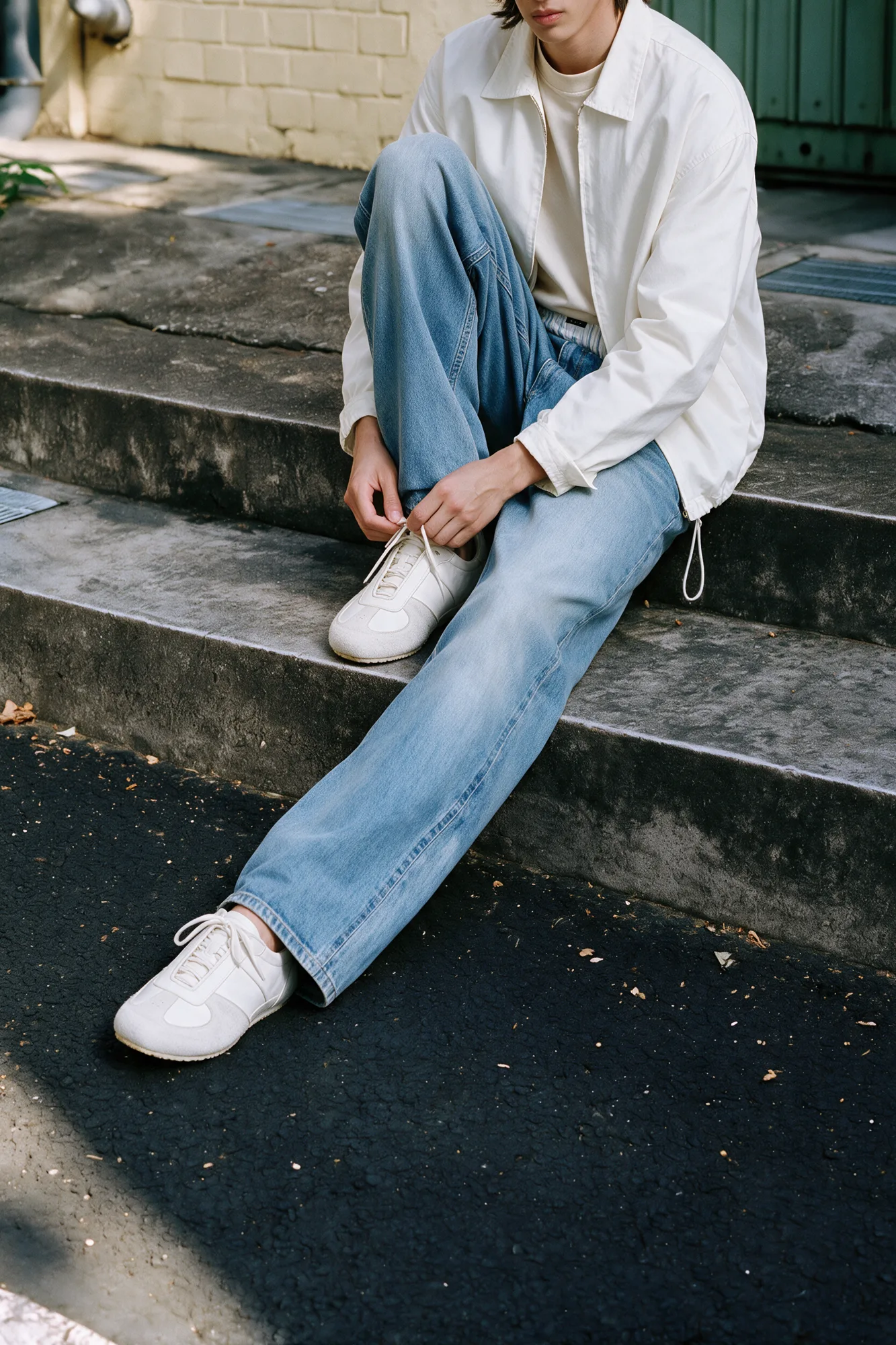 Seated studio portrait featuring white trainers