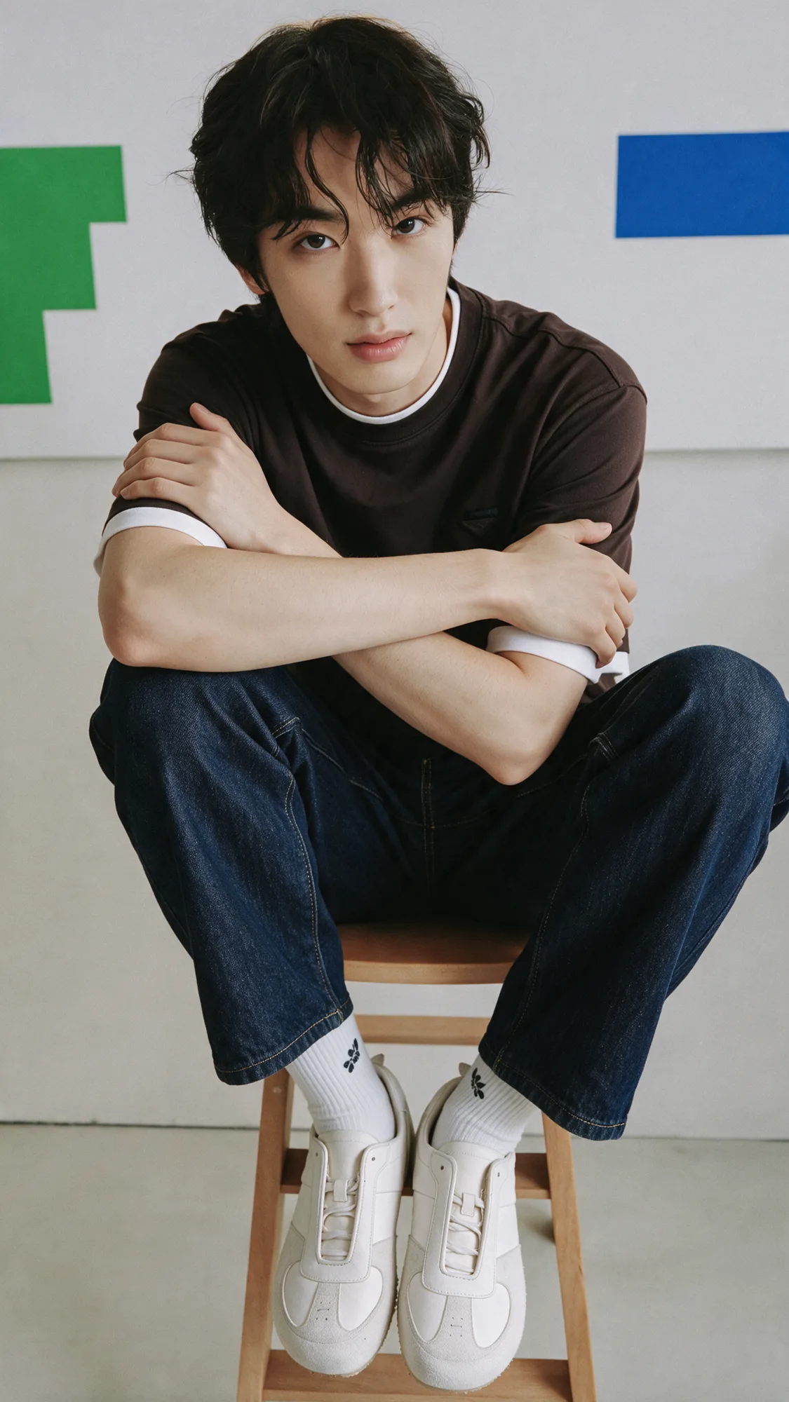 White trainers worn with dark trousers in a sunlit interior